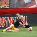 Una portera realizando una caída lateral durante un entrenamiento