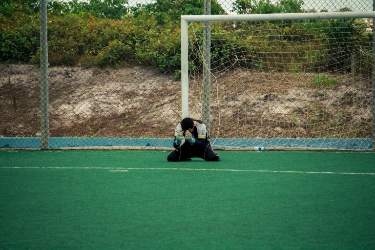 Portero en el suelo de rodillas.