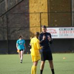 Entrenador hablando con una portera de fútbol.